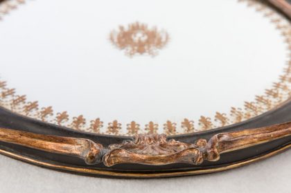 Bajoplato de espejo y marco negro con adornos dorados