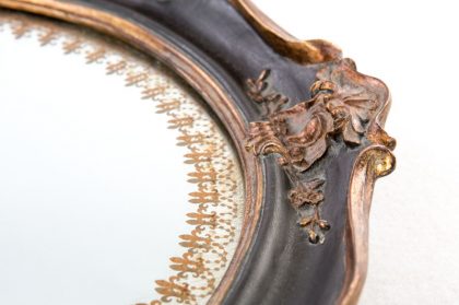 Bajoplato de espejo y marco negro con adornos dorados